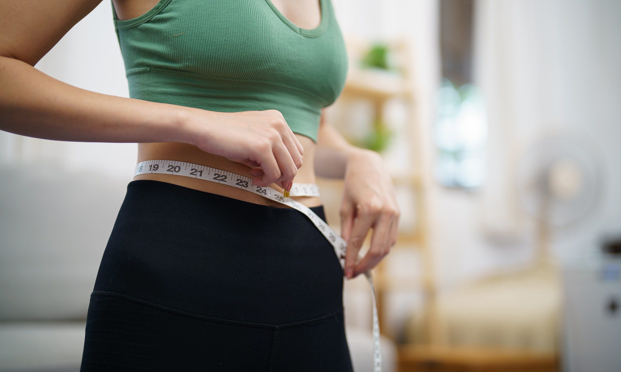 Slim woman measuring waist